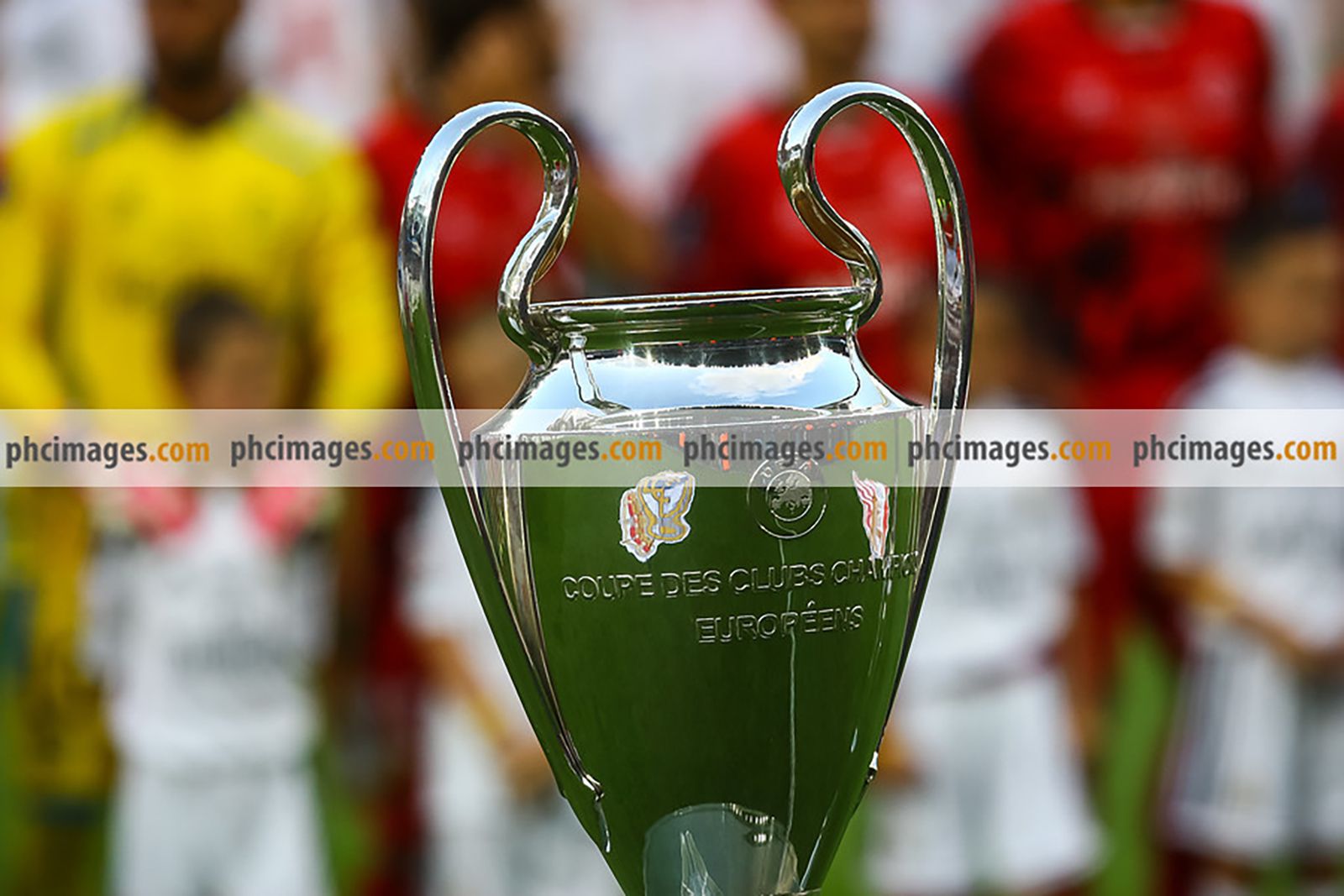 The badges of the two teams are reflected in the Champions League trophy