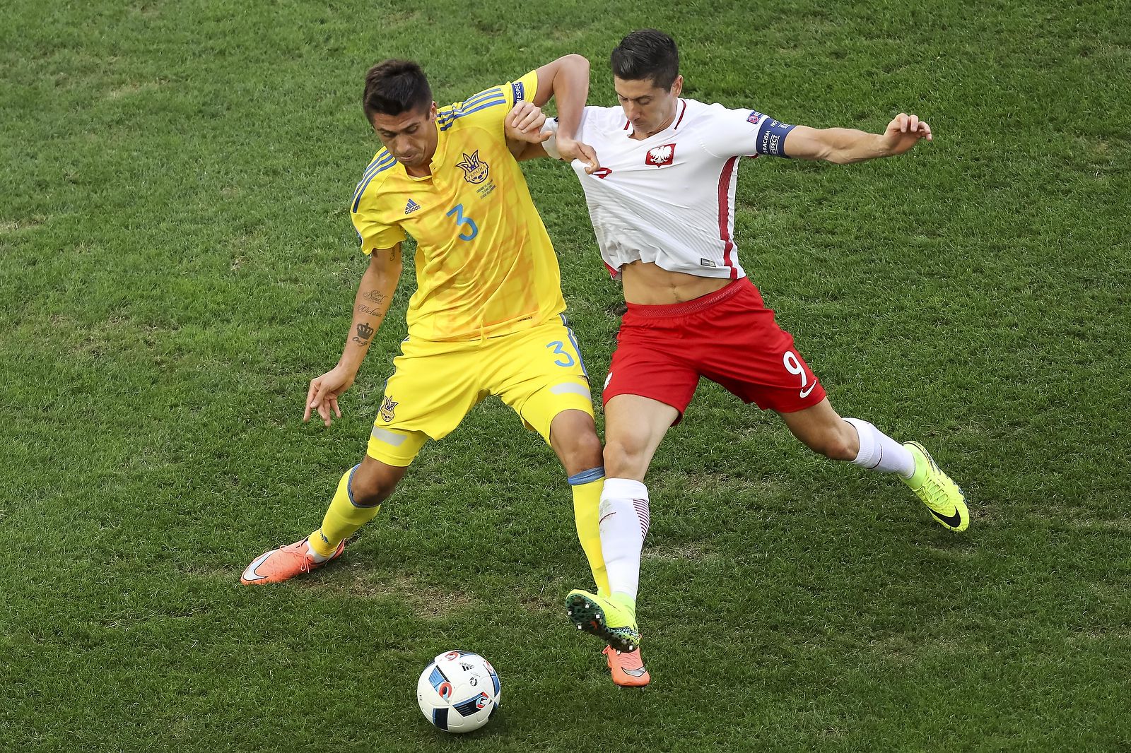 Yevhen Khacheridi and Robert Lewandowski compete for the ball