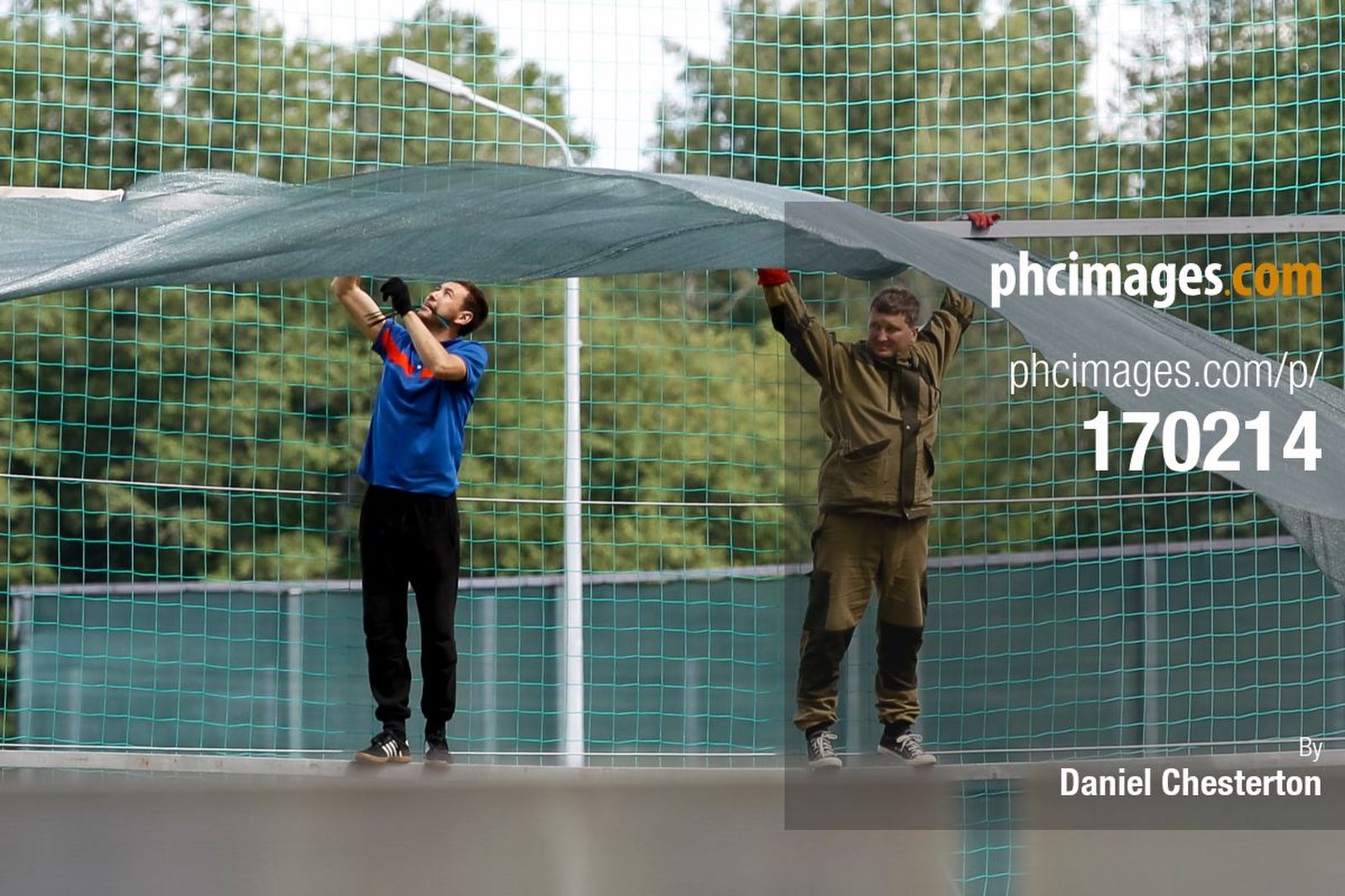 Workers install a large fence at Stadium Spartak Zelenogorsk