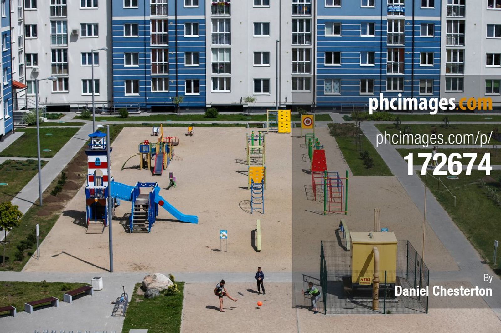 Young kids play football in a park in front of a block of apartments. Taken from our apartment window as we made toast on our day off after the England match