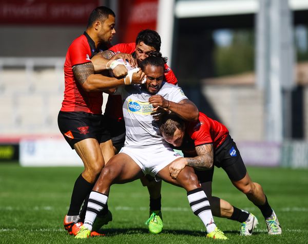 Josh Drinkwater of London Broncos is tackled vs Salford Red Devils