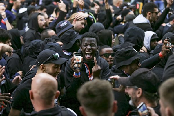 A PSG fan taunts Newcastle fans with a photo of the Sunderland badge